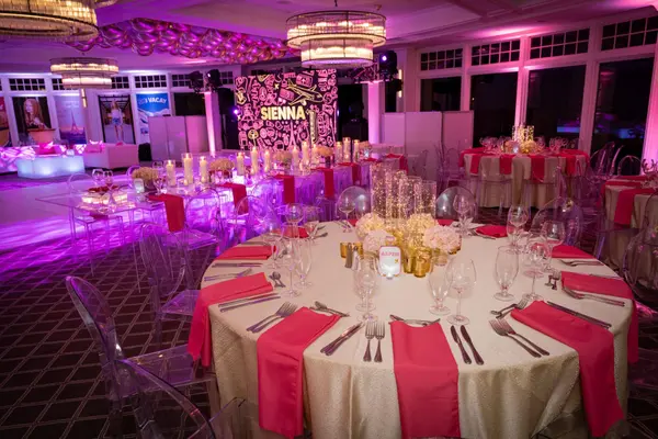 Sienna's Bat Mitzvah ballroom with gold sequin tables and Sienna logo stage