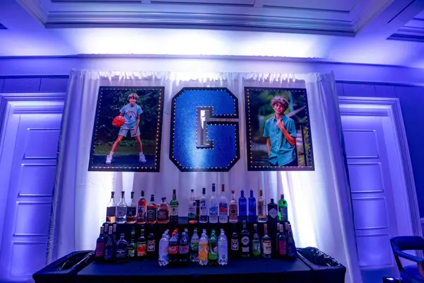 Glitter G logo sign and honoree photos above the bar