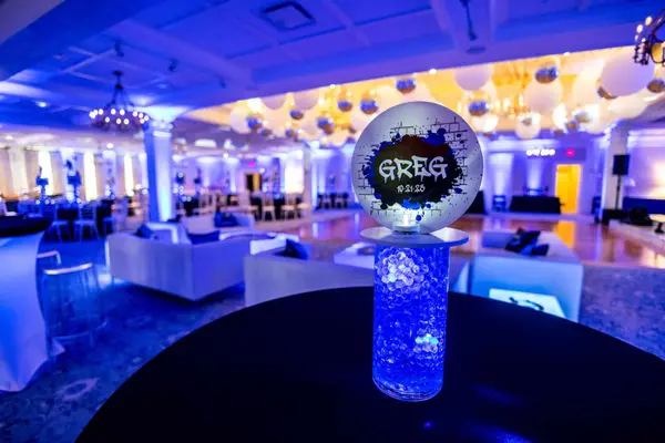 Greg graffiti logo topper on a lit blue crystal cylinder