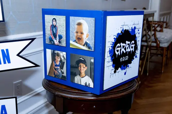Greg logo photo cube with childhood pictures on the entry table