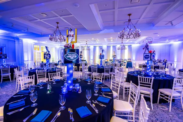 Jets themed centerpiece on a black table with blue napkins