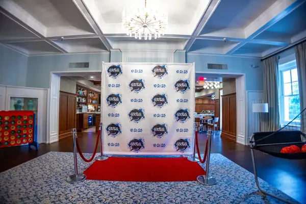 Greg logo step and repeat with red carpet and stanchions