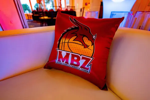 Red MBZ dragon logo pillow on a white sofa, Mike's Bar Mitzvah