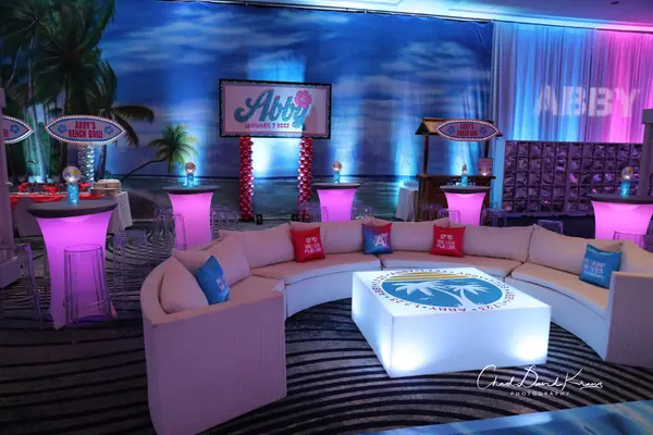 Curved lounge with Abby logo LED table before the beach mural