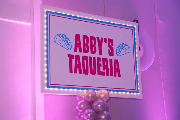 Abby's Taqueria lit sign with pink balloons at Abby's Bat Mitzvah
