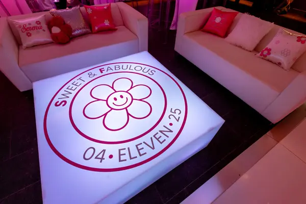 Glowing logo coffee table between lounge sofas at Serena's Bat Mitzvah