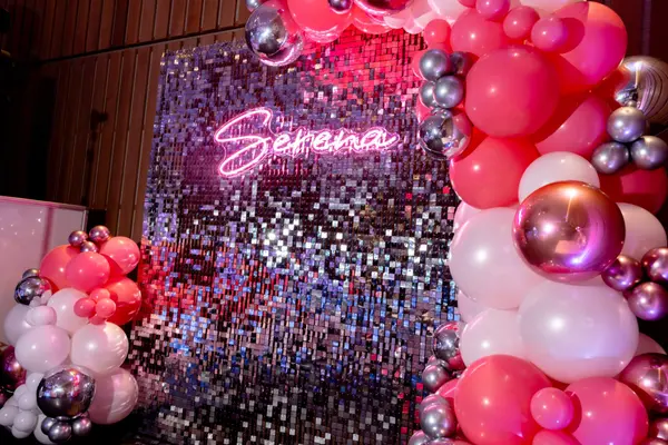 Serena neon sign on a sequin wall with pink balloon garland