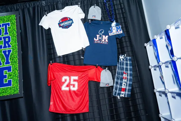 Custom JM jerseys, tees and beanies displayed on the swag wall