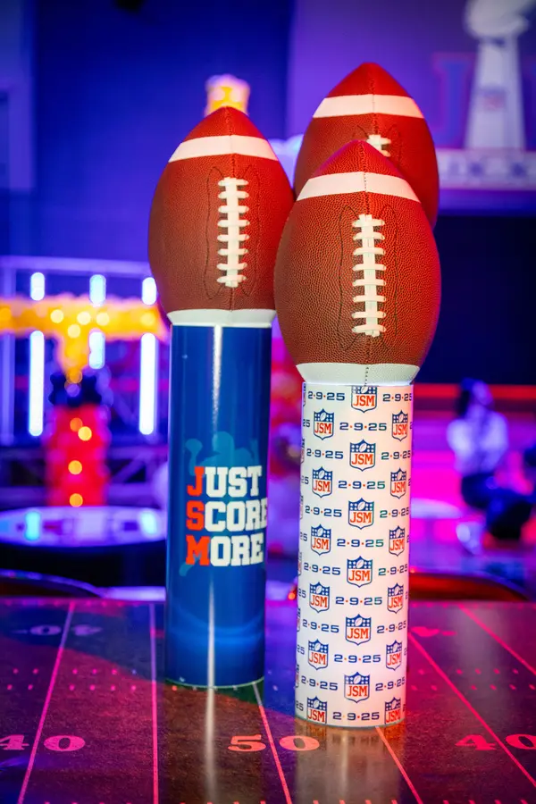 Just Score More and JSM logo cylinder centerpieces with footballs
