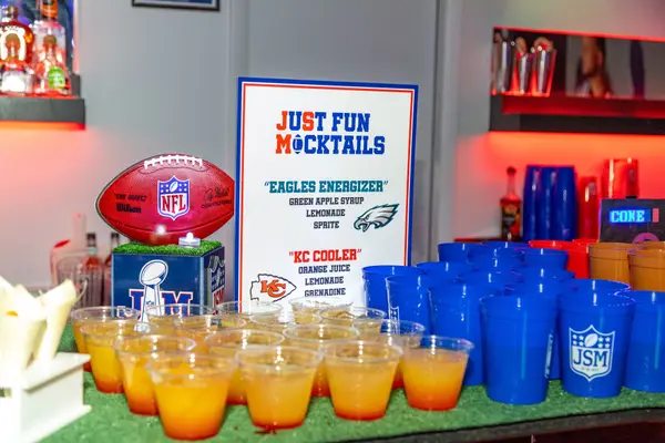 Just Fun Mocktails sign with JSM logo cups on the turf bar