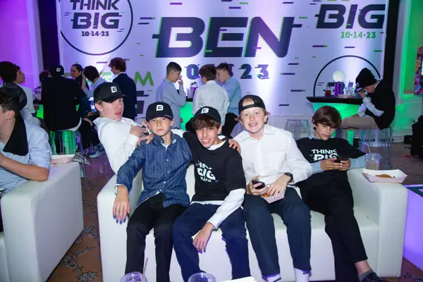 Guests on white lounge sofas before Ben's Bar Mitzvah logo backdrop