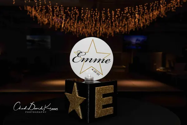 Emme star logo sign on a glitter cube under fairy lights