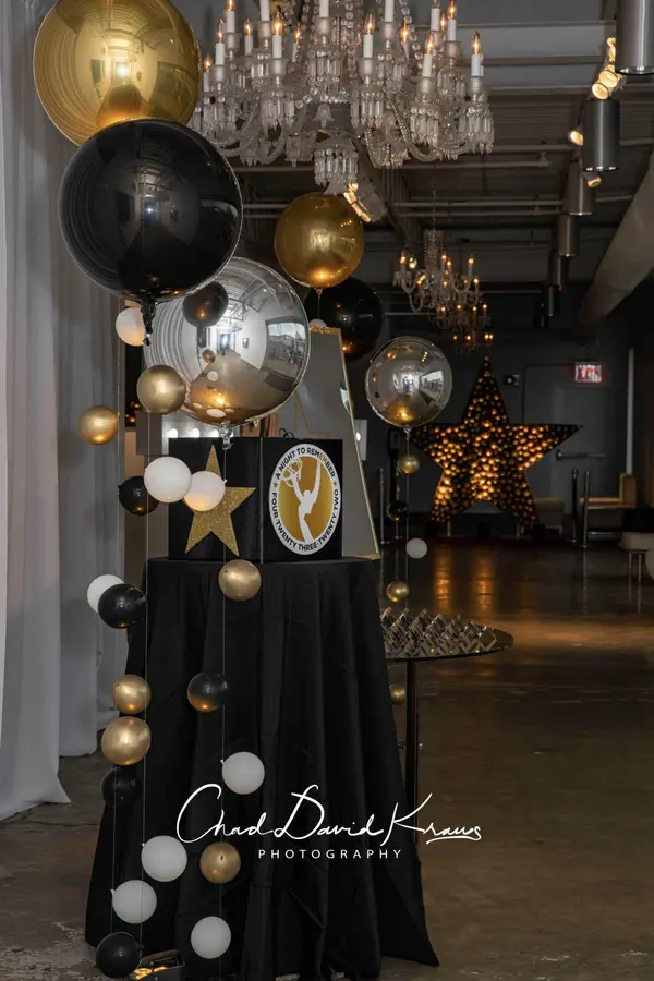 Gold, black and silver orb balloons over the gift box table