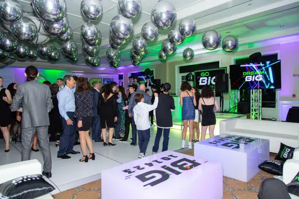 Guests dancing beside Big logo lounge tables at Ben's Bar Mitzvah