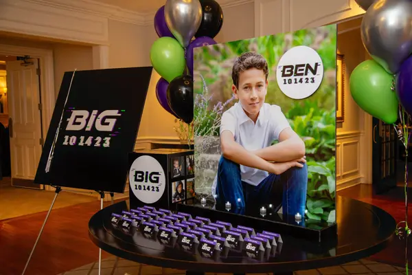 Ben's Bar Mitzvah escort card table with photo display and balloons