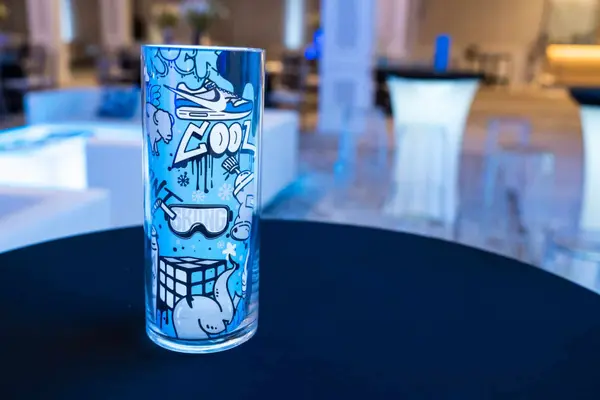 Owen's Bar Mitzvah graffiti-themed logo vase on a high-top table