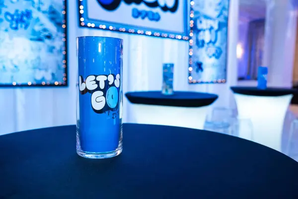 Owen's Bar Mitzvah Let's Go logo vase on a cocktail table