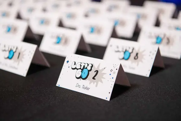Owen's Bar Mitzvah tented escort cards with Let's Go logo
