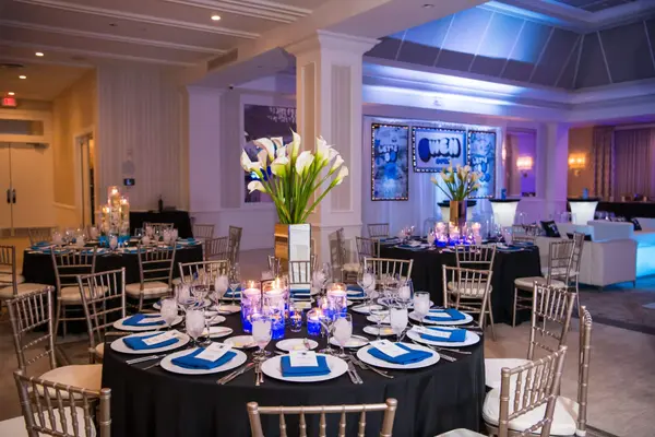 Owen's Bar Mitzvah ballroom tables with calla lilies and logo backdrop