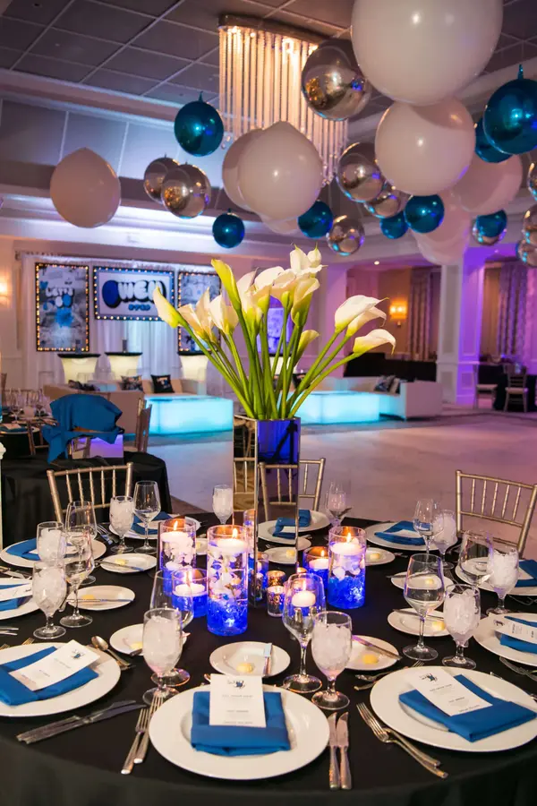 Owen's Bar Mitzvah calla lily centerpiece with blue votives and balloon ceiling