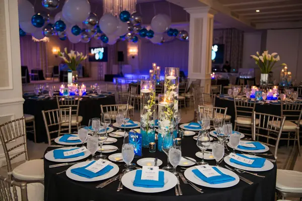 Owen's Bar Mitzvah candle and orchid centerpiece in a purple-lit ballroom