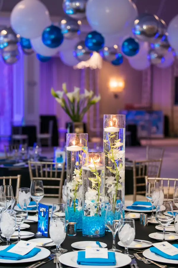 Owen's Bar Mitzvah floating candle cylinders with orchids and blue gel beads