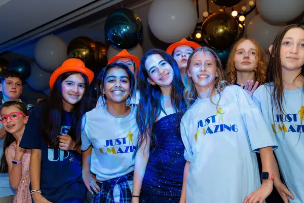 Emily's Bat Mitzvah guests in Just Emazing shirts under balloon ceiling