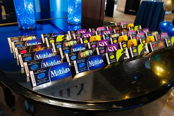 Emily's Bat Mitzvah Broadway ticket escort cards on a mirrored table