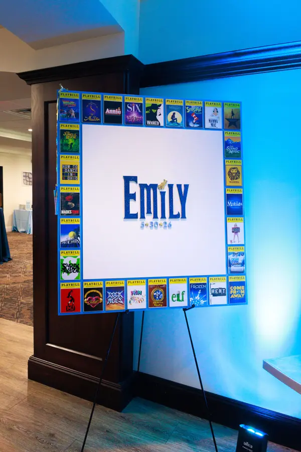 Emily's Bat Mitzvah Playbill-bordered logo sign-in board on an easel