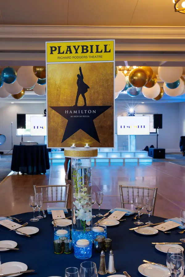 Emily's Bat Mitzvah Hamilton Playbill centerpiece on an orchid cylinder