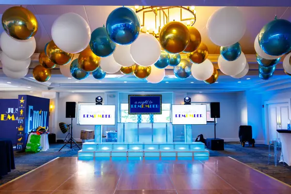 Emily's Bat Mitzvah lit stage with logo screens under balloon ceiling