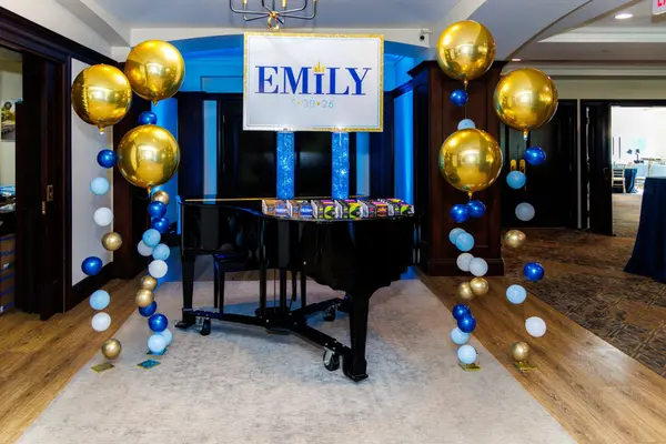 Emily's Bat Mitzvah logo sign and balloon columns over grand piano