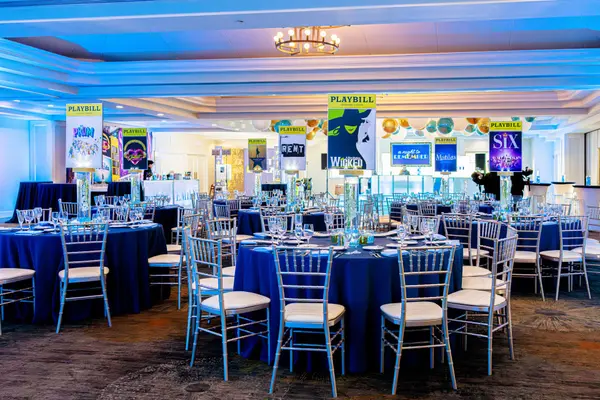Emily's Bat Mitzvah ballroom of Playbill centerpieces and navy tables