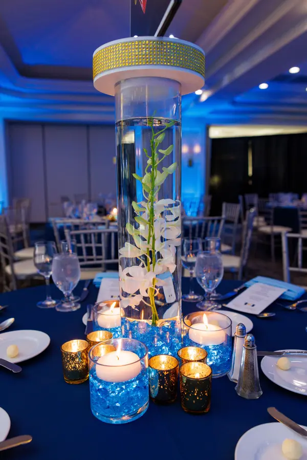 Emily's Bat Mitzvah orchid cylinder centerpiece with floating candles and gold votives